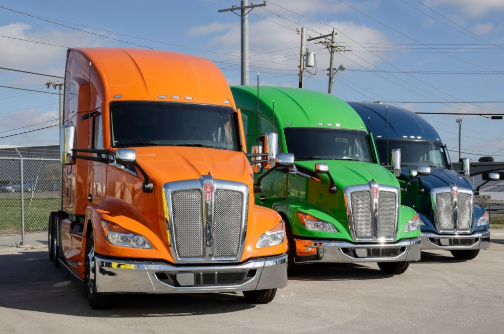 Different colors of Kenworth trucks in a row