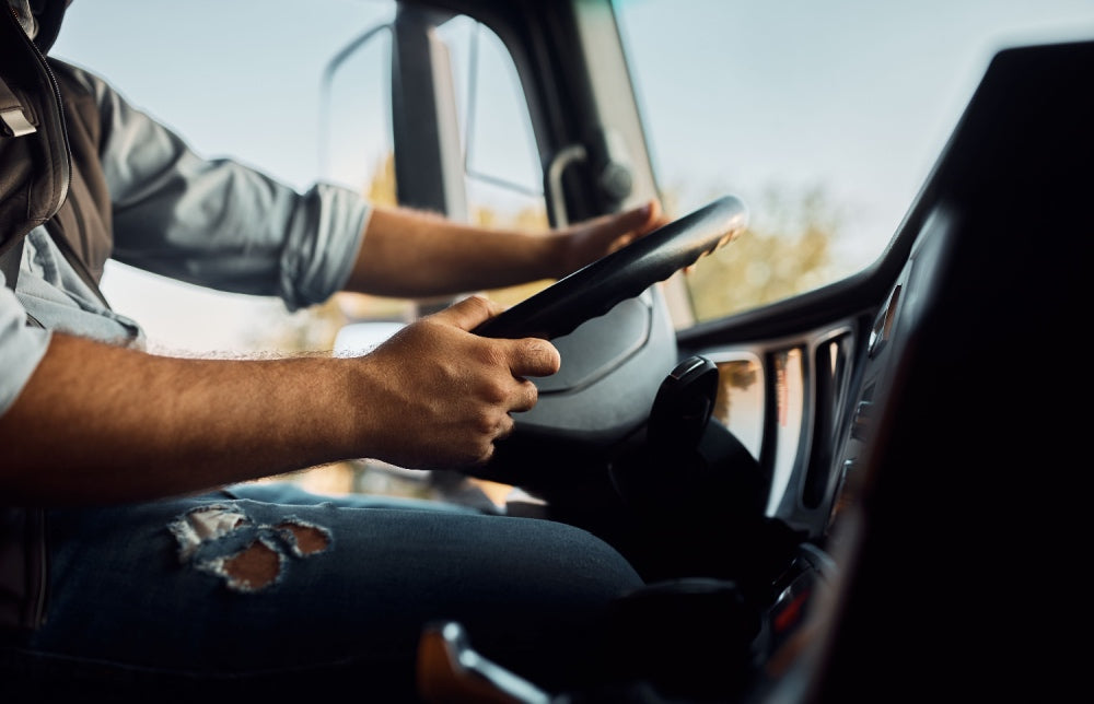 truck driver holding wheel of semi truck